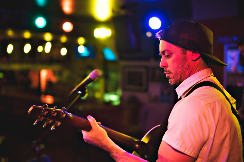 A cool and nice Man playing guitar at a bar